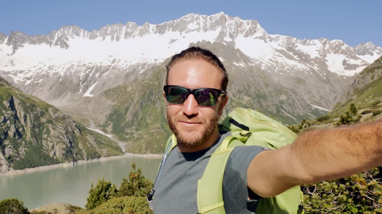 男性徒步旅行者在美丽的风景前自拍视频素材