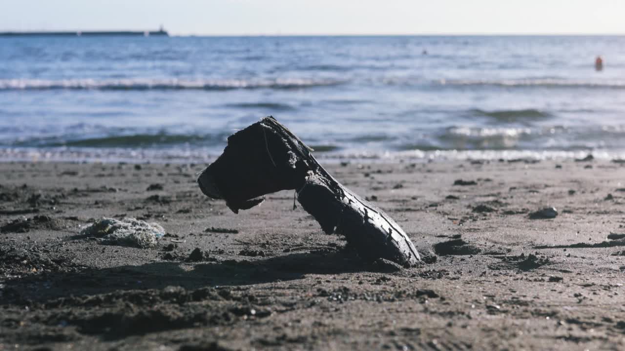 一个轮胎被抛到岸上的海滩上视频素材