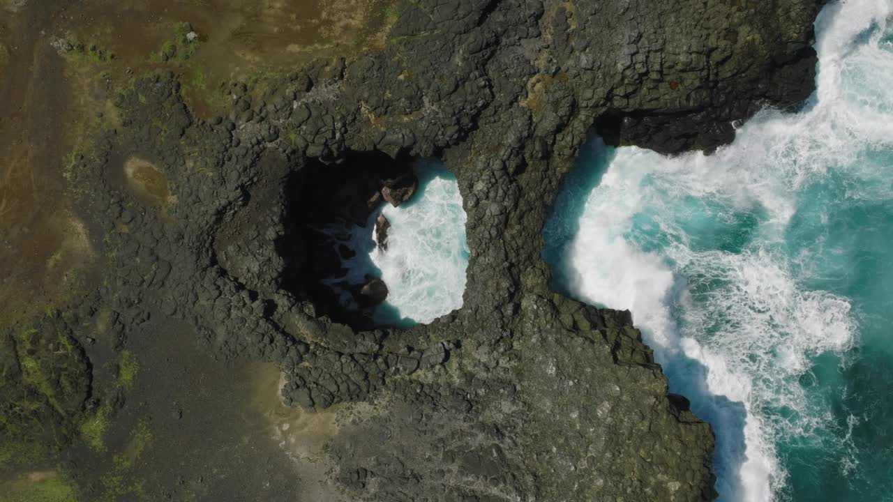 航拍到的波涛汹涌的岩石海岸和清澈的蓝色海水视频素材