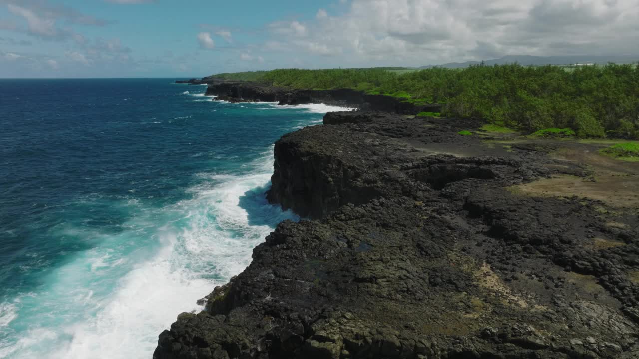 航拍到的波涛汹涌的岩石海岸和清澈的蓝色海水视频素材