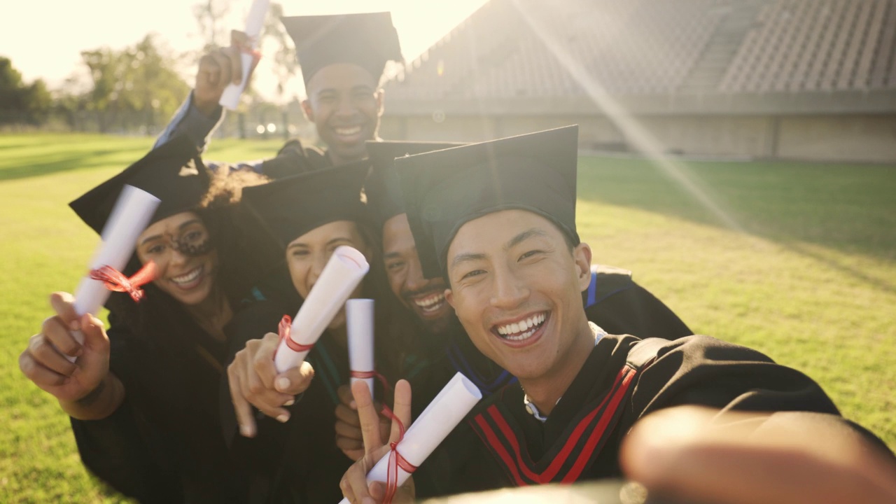 不同的学生在毕业典礼上用手机自拍。拿着文凭和学位的大学毕业生在社交媒体上微笑。毕业的朋友们感到自豪和庆祝视频素材