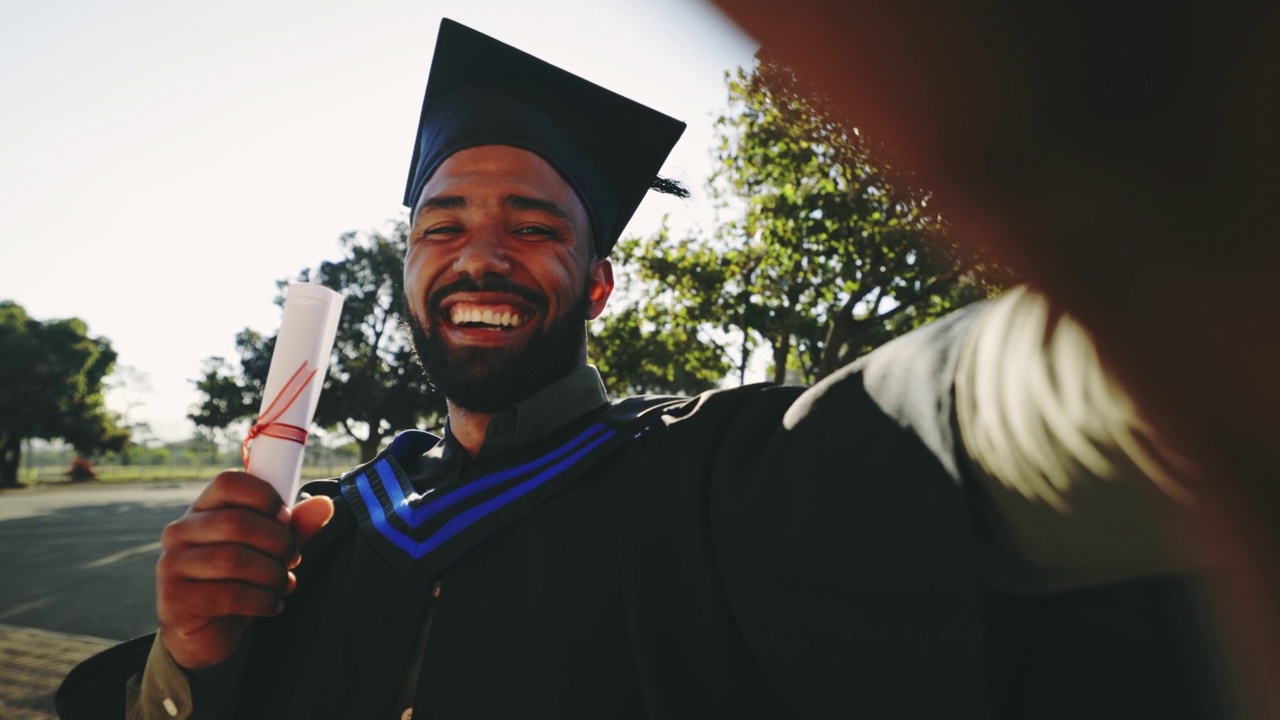 一名年轻的男学生在毕业典礼上开怀大笑的自拍照片。一名男子大学毕业后在校园外拿着毕业证拍照视频素材