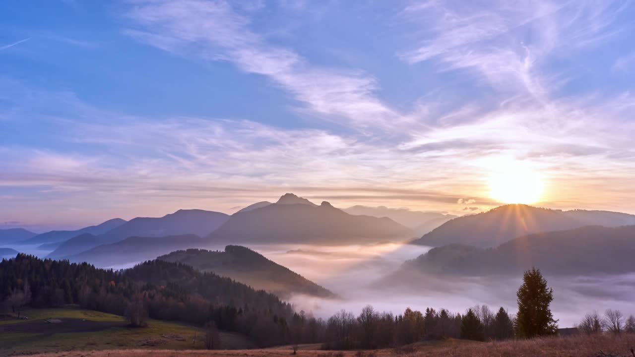 雾在山谷中形成了美丽的山景在夕阳下。从白天到黑夜的过渡。间隔拍摄4 k视频素材