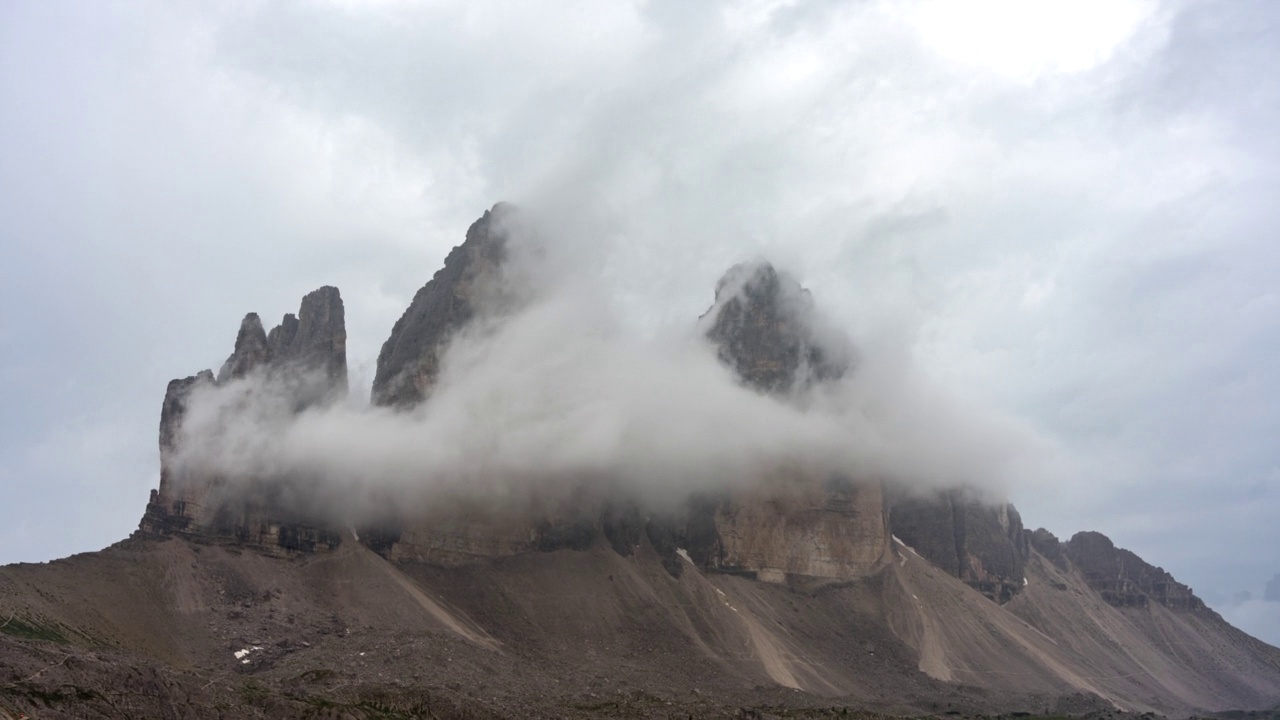 随着云和雾移动的日出在大雨后经过Tre Cime, Dolomites，意大利视频素材