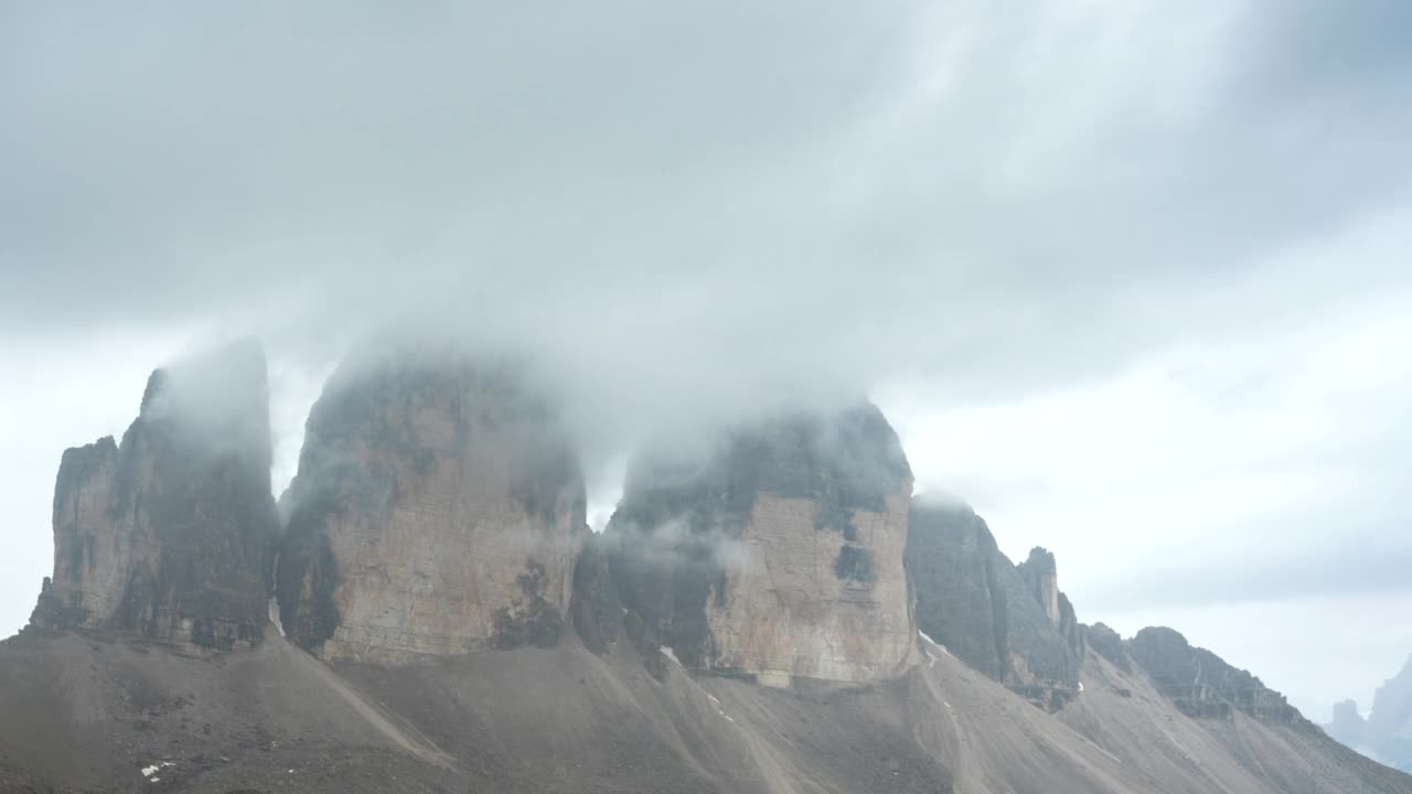 随着云和雾移动的日出在大雨后经过Tre Cime, Dolomites，意大利视频素材