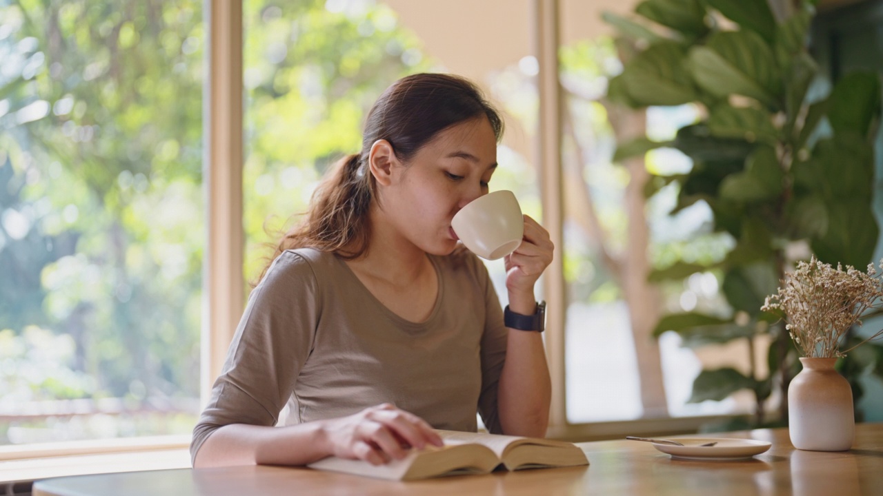 女人在休闲时间看书喝咖啡视频素材