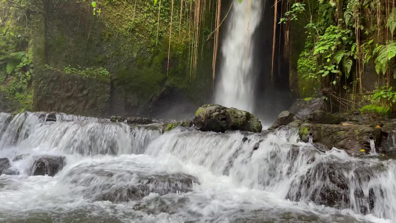 近距离观察瀑布在热带雨林的岩石上迅速流下。印尼巴厘岛乌布的Sumampan瀑布，4K视频。视频素材