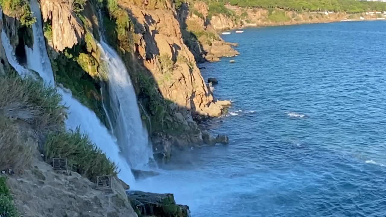 瀑布从高处泻入海边的大海。旅游与旅游理念视频素材