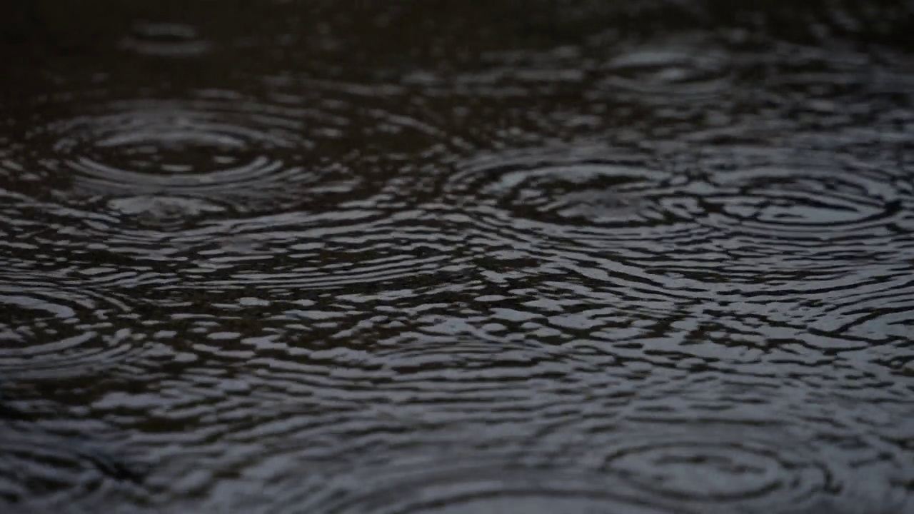 4K慢动作视频，下雨天的水坑上泛起阵阵涟漪。视频素材