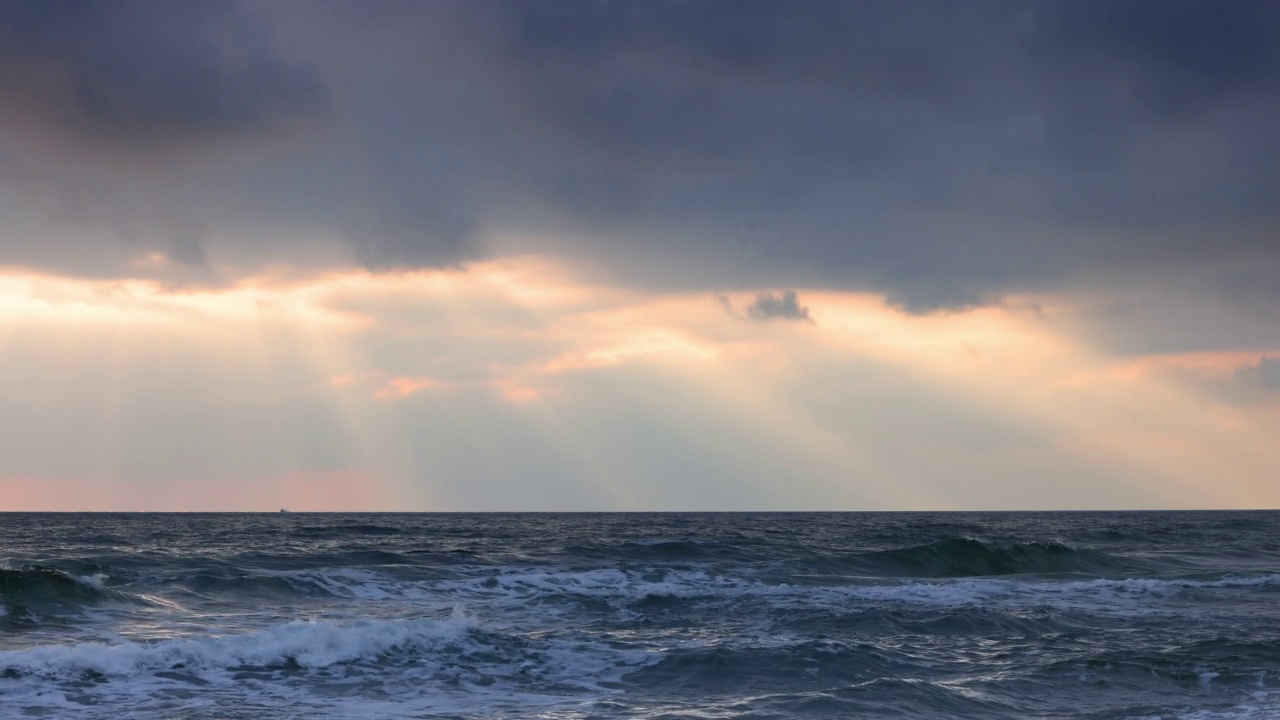 海洋海滩日出与黑暗的天空乌云和太阳光线在海浪视频素材