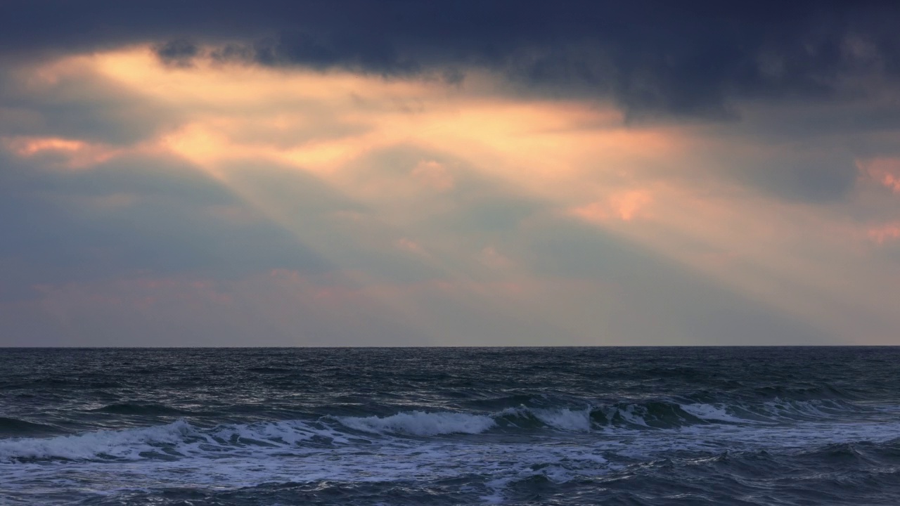 阳光照耀下的暴风雨天空。美丽的海景、沙滩和海浪视频素材