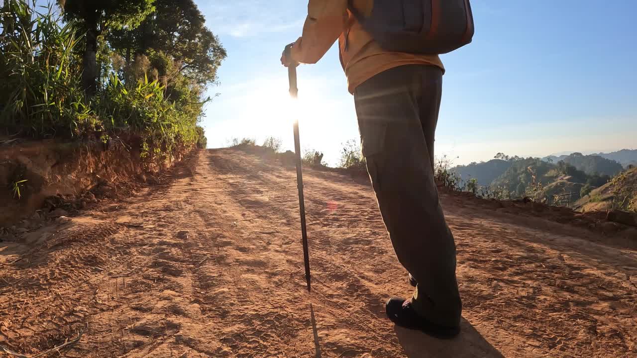 一名亚洲妇女走在泰国北部农村山区的一条土路上。视频素材