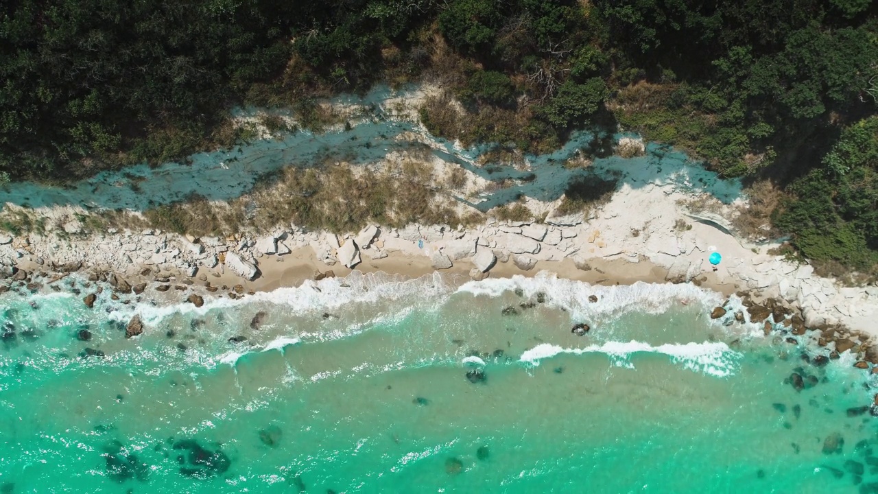 海浪拍打悬崖的鸟瞰图。拥有石头和海滩的美丽天堂般的海岸线视频素材