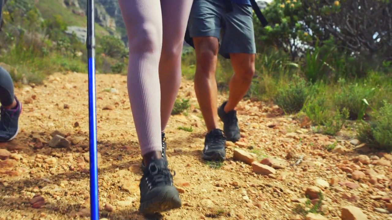 夏日里一群朋友徒步登山的特写。活跃的人在大自然中散步是他们锻炼和健身的一部分。运动健将在户外爬山视频素材