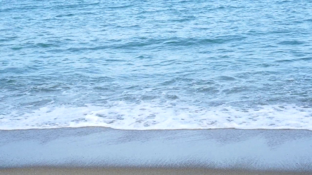 岸边的黑色海浪与泡沫大气在海滩自然背景。泰国热带岛屿的夏日涟漪。假期旅游的概念。视频下载