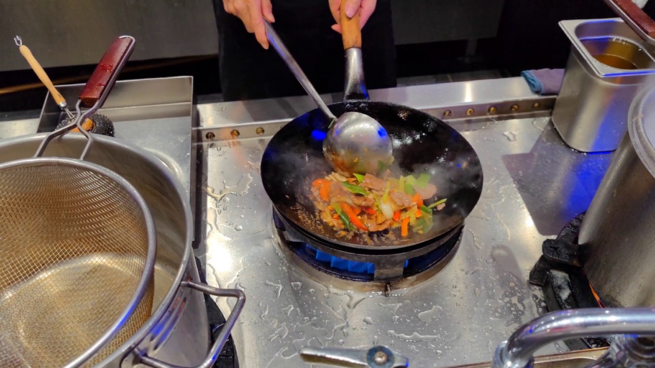 在炒锅餐厅，各种蔬菜和亚洲酱肉在炒锅中通过现场烹饪进行翻炒视频素材