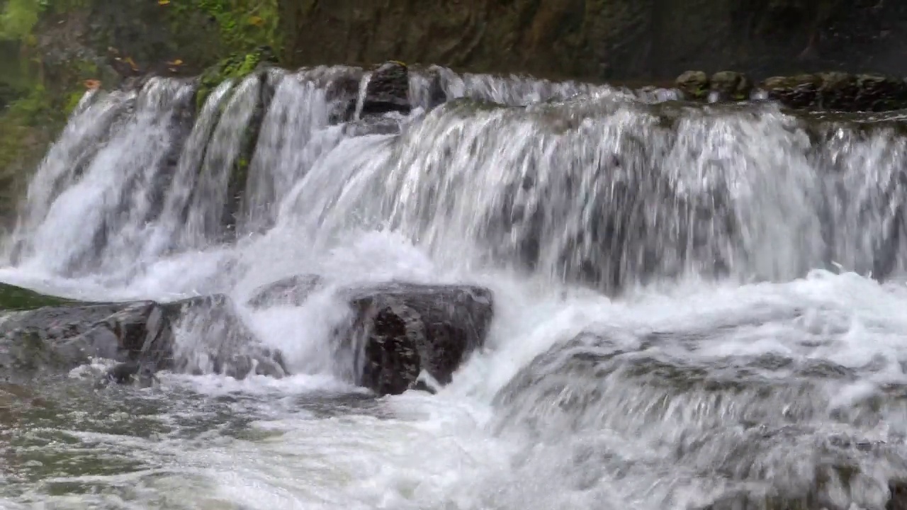 近距离观察瀑布在热带雨林的岩石上迅速流下。印尼巴厘岛乌布的Sumampan瀑布，4K视频。视频素材