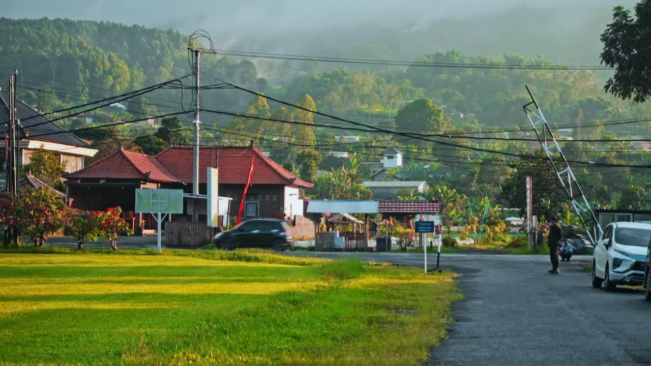 印度尼西亚街道，红色屋顶的ai房子，绿色的雨林和云的背景视频素材