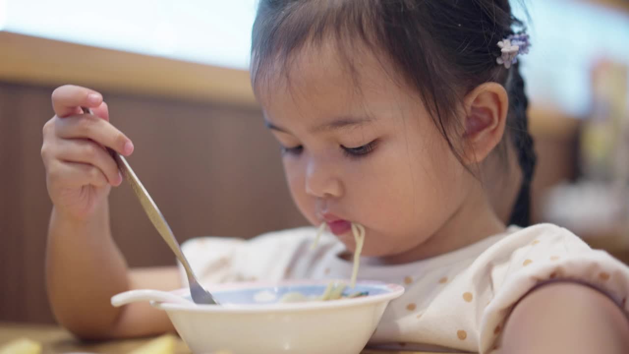 特写的亚洲小女孩喜欢在餐厅吃日本面视频素材