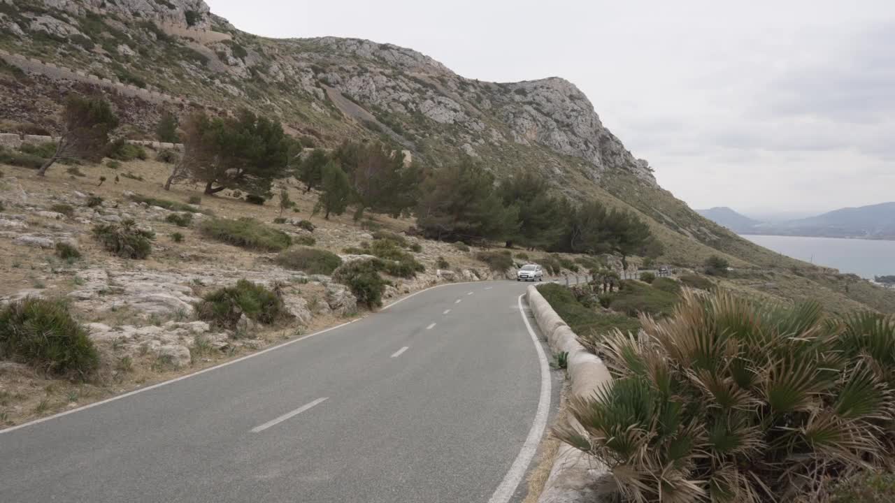 自行车和汽车在风景优美的道路上俯瞰波伦卡港，伊斯科洛梅尔，波伦卡港，马略卡岛，巴利阿里群岛，西班牙，地中海，欧洲视频素材