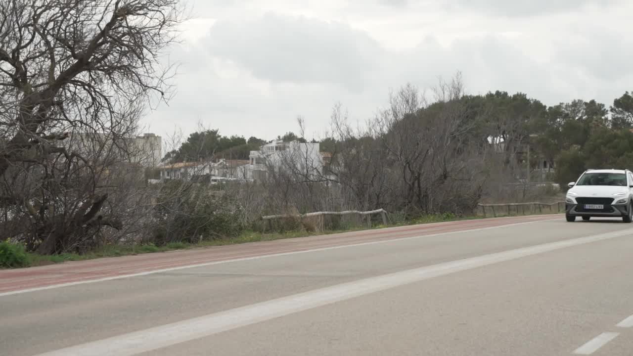 骑自行车的人在海岸公路进入波伦卡港和山脉的背景，波伦卡港，马略卡岛，巴利亚利群岛，西班牙，地中海，欧洲视频素材