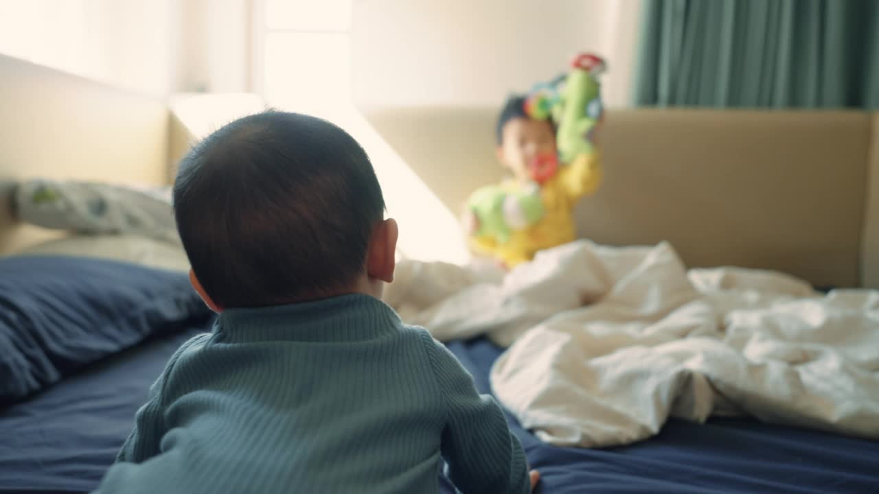 两个兄弟姐妹在婴儿围栏里玩得很开心。视频素材