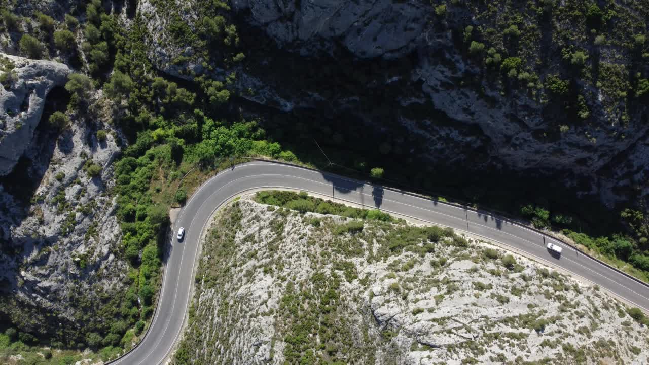 鸟瞰图，汽车和卡车行驶在弯曲的山路上。视频素材