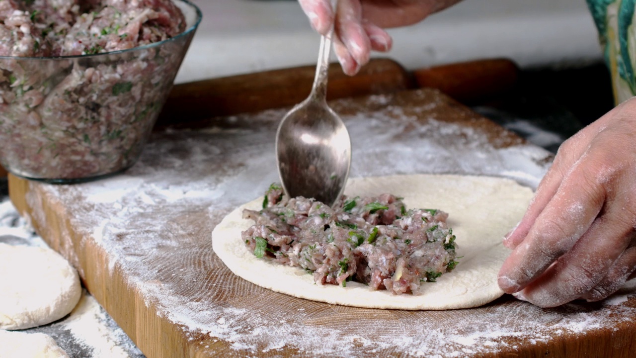 厨师制作肉饼，用生肉末加洋葱和香草包在面团里。视频素材