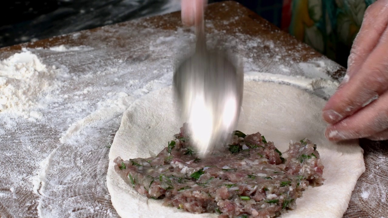 厨师制作肉饼，用生肉末加洋葱和香草包在面团里。视频素材