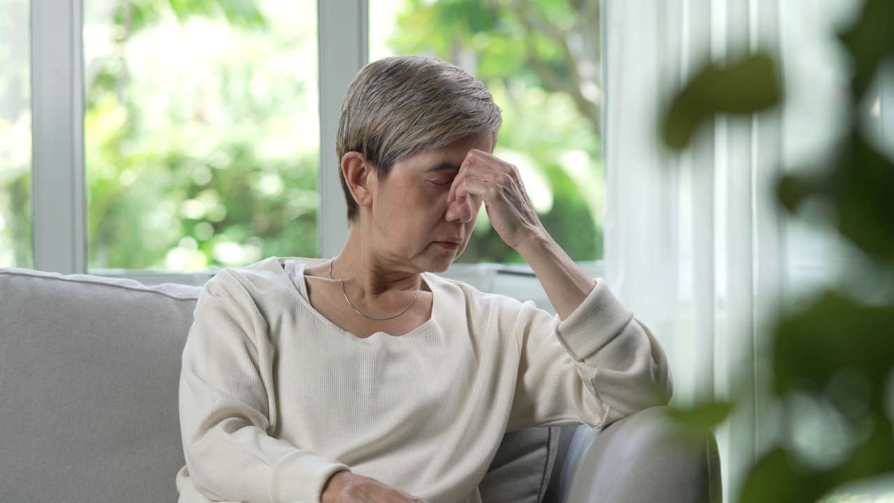 中年亚洲妇女看起来很苦恼，担心和沮丧。视频素材