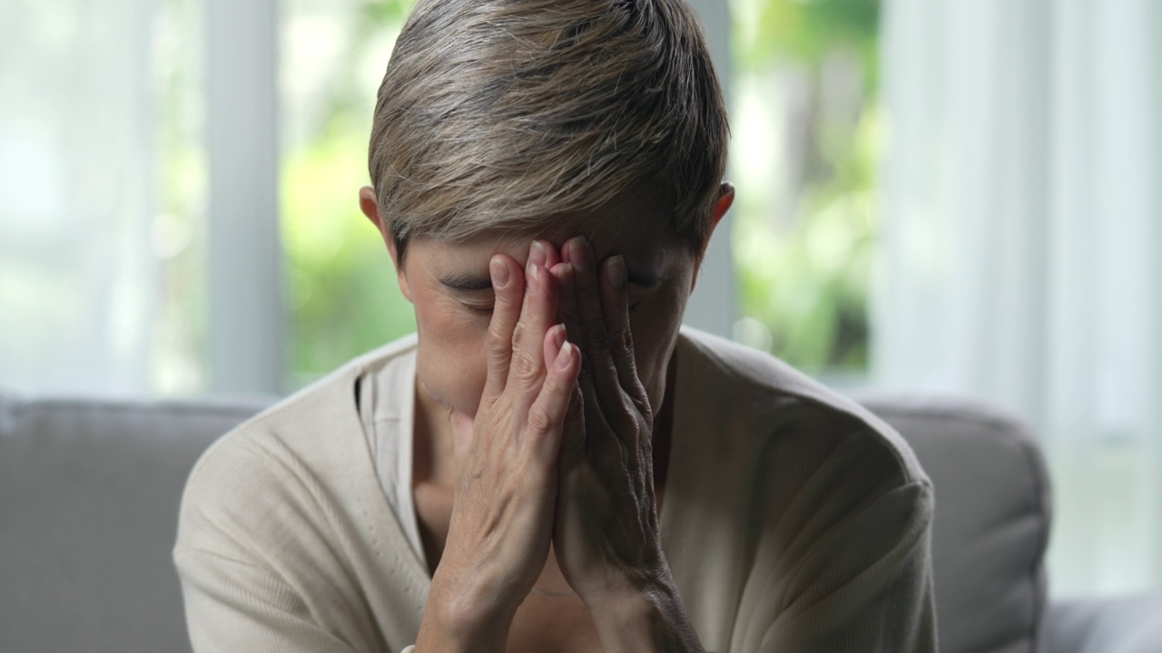 中年亚洲妇女看起来很苦恼，担心和沮丧。视频素材