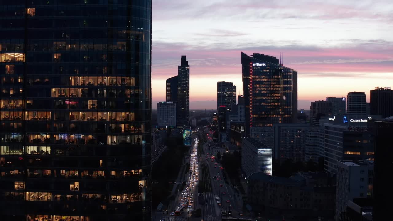 在暮色苍穹的映衬下，市中心摩天大楼倒映。繁忙的多车道道路和交叉路口。波兰华沙视频素材