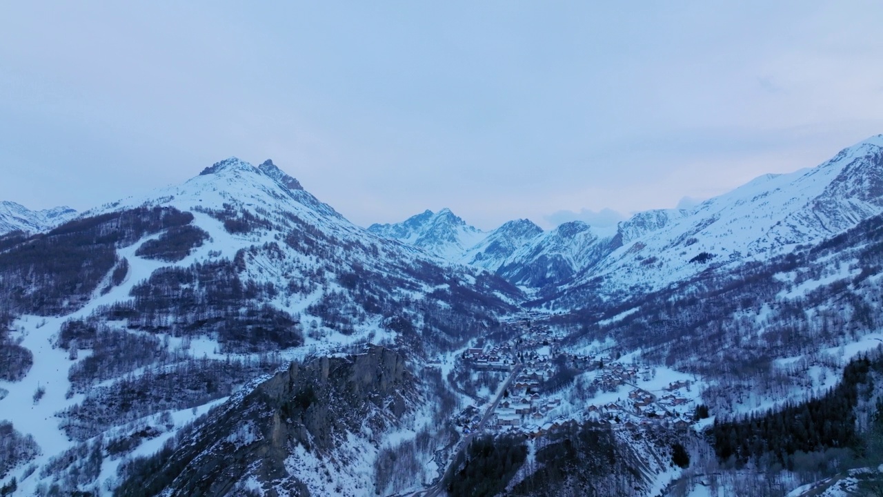 空中前进拍摄教堂在雪山在天空下的小镇-瓦卢瓦，法国视频素材