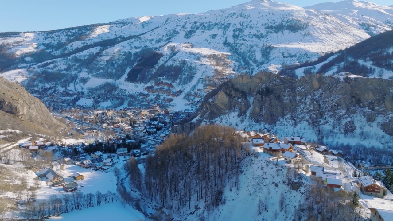 在晴朗的天空下，城市景观在雪山中的鸟瞰图-瓦卢瓦，法国视频素材