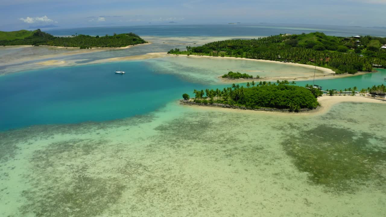 空中前进风景拍摄的树木在海上的岛屿在晴天-苏瓦，斐济视频素材