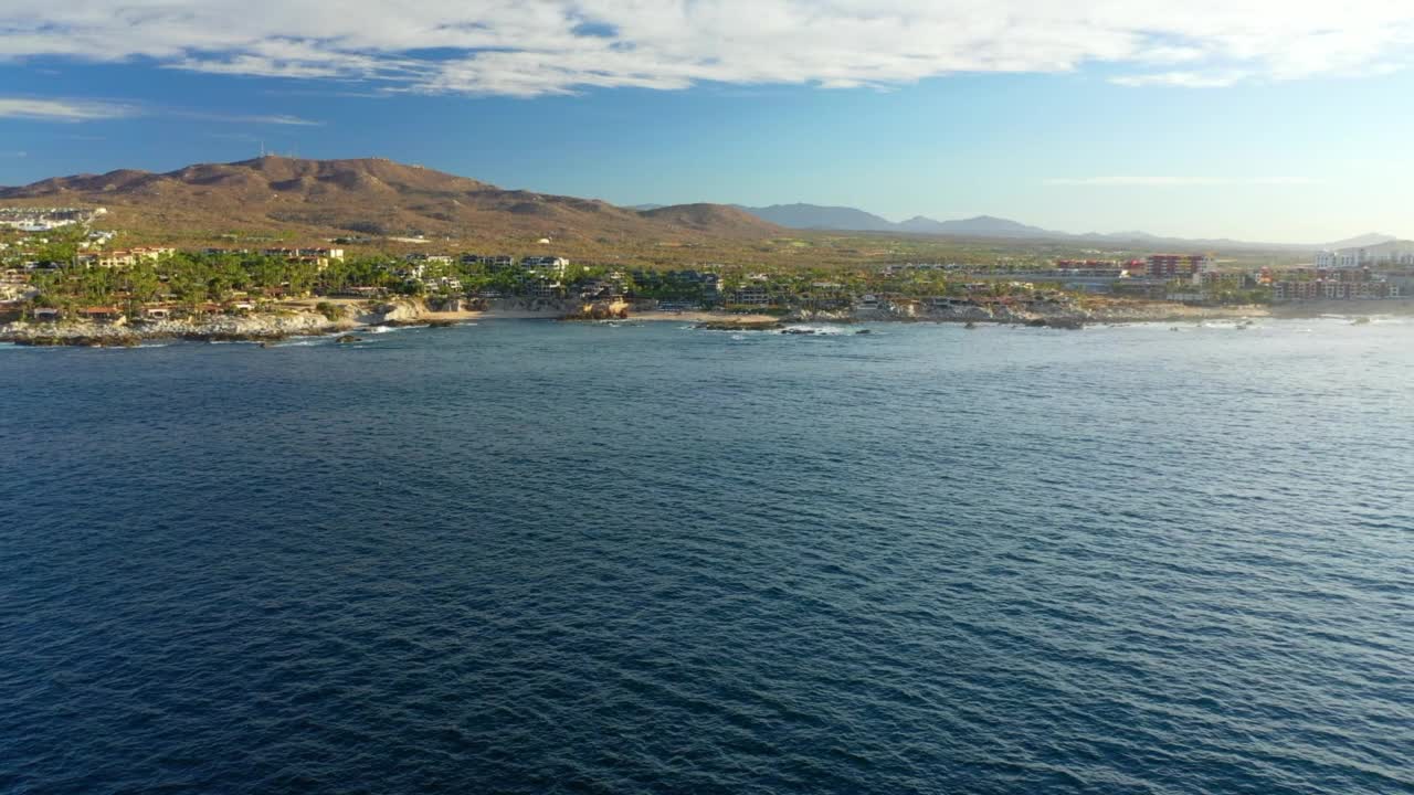 在海滩上的豪华酒店的空中美景，无人机在海上向后飞行-卡波圣卢卡斯，墨西哥视频素材