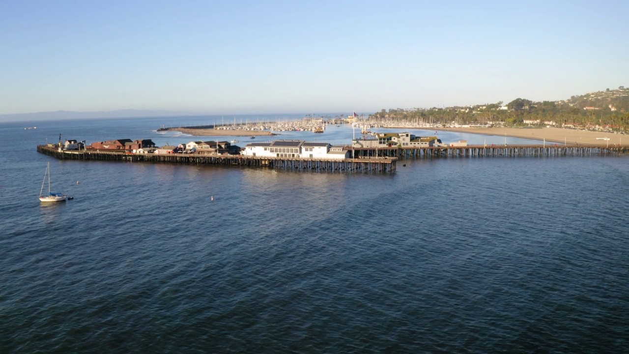 空中向前拍摄海上码头上的结构，无人机向前飞行在波浪海上-圣巴巴拉，加州视频素材