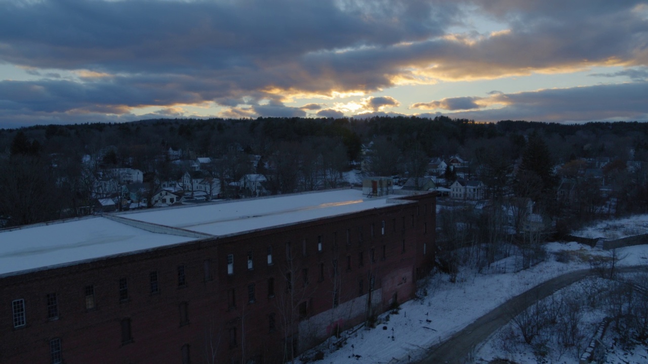 空中前进拍摄的住宅在雪镇下的多云的天空在日落-奥兰治，马萨诸塞州视频素材