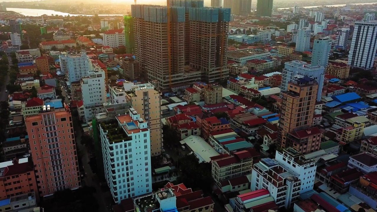 空中倾斜拍摄的河流在住宅城市，无人机向前飞行的建筑物-金边，柬埔寨视频素材