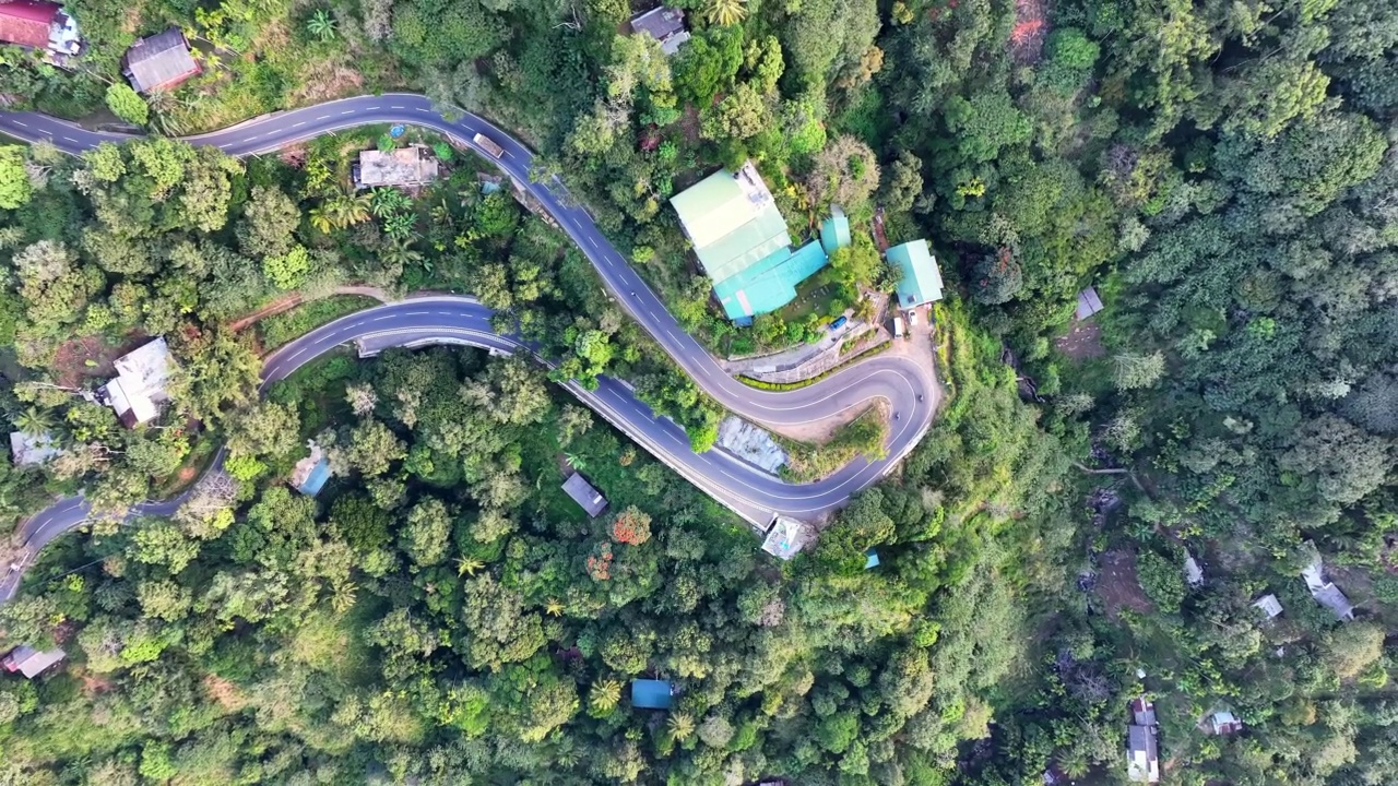 空中平移拍摄的车辆移动在山路上，无人机飞越绿色的树-埃拉，斯里兰卡视频素材