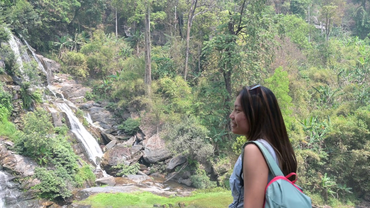 一名亚洲妇女在瀑布边徒步旅行的肖像视频素材