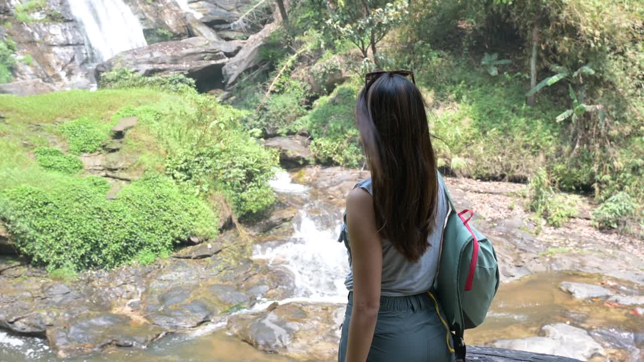 一名亚洲妇女在瀑布边徒步旅行的肖像视频素材