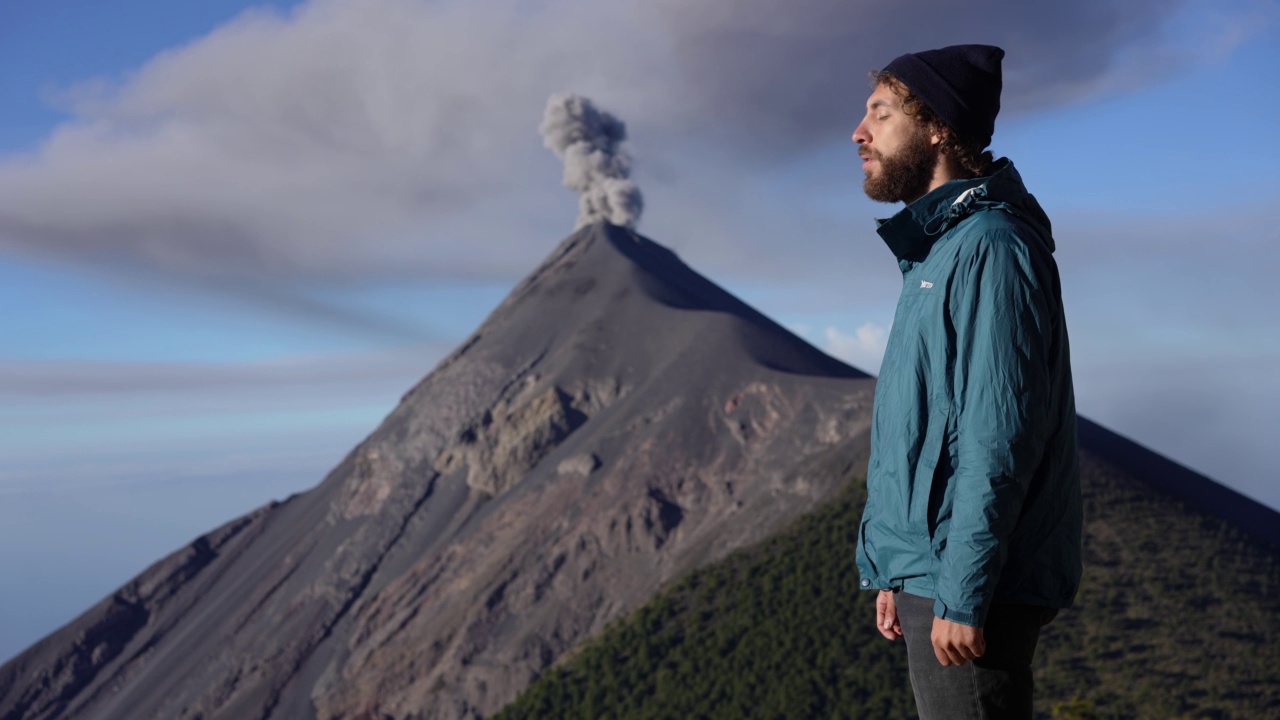 危地马拉，一名男子站在富埃戈火山爆发的背景上视频素材