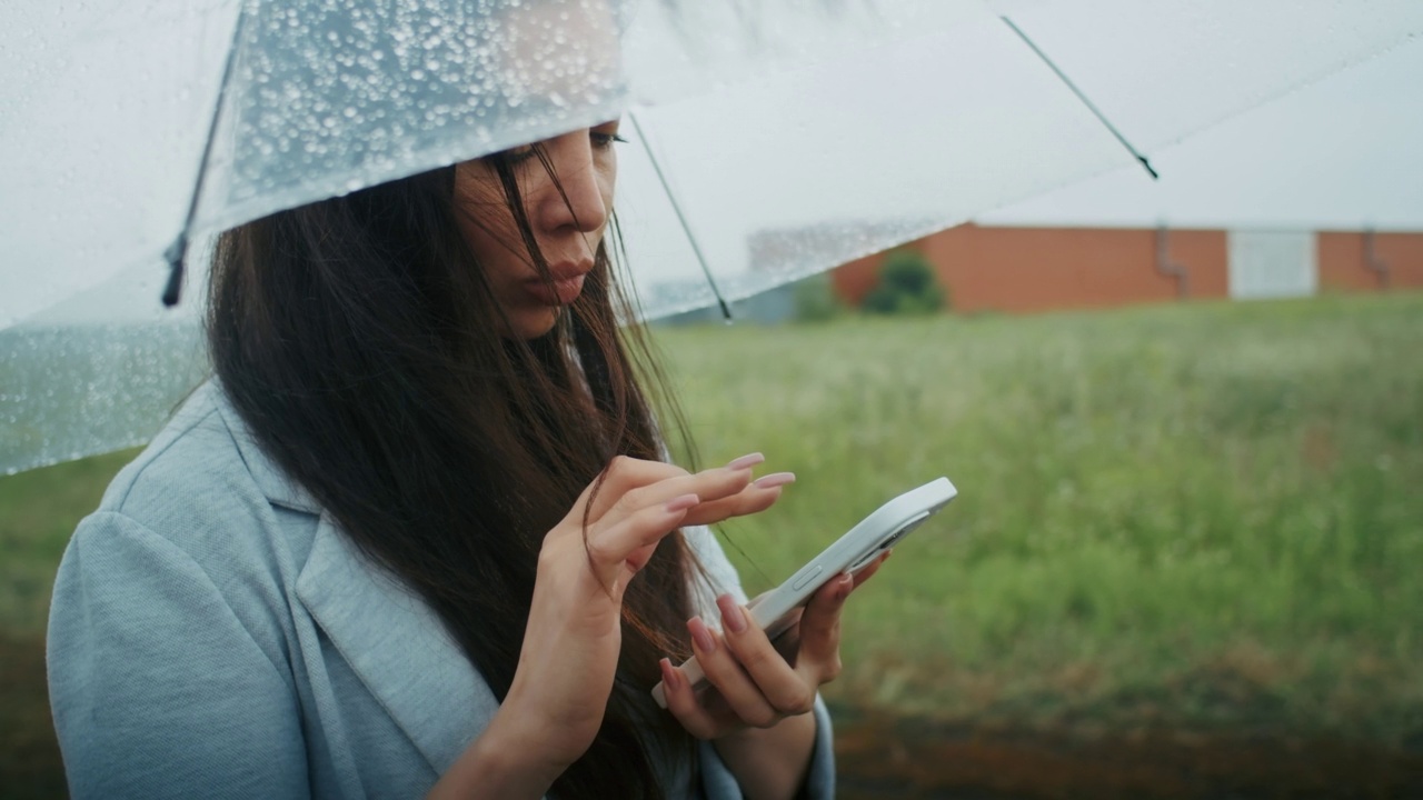 一个悲伤的亚美尼亚女人在雨中打电话，视频素材