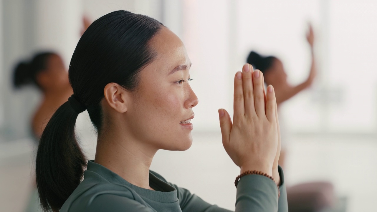 年轻活跃的亚洲女性练习瑜伽做莲花练习，在课堂上以合十礼半莲花姿势冥想。健康的女人冥想是拥有一个健康平衡的头脑、身体和灵魂视频素材