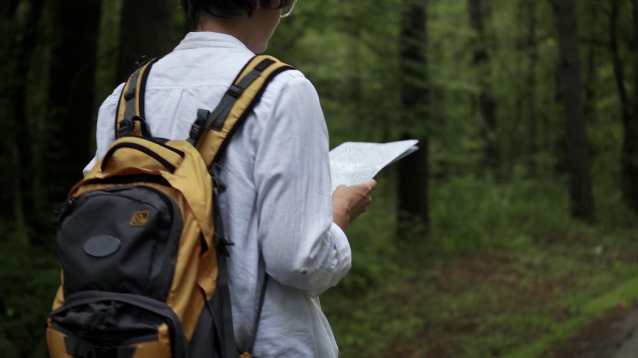 年轻女子背包旅行，看地图，徒步旅行的欧洲游客视频素材