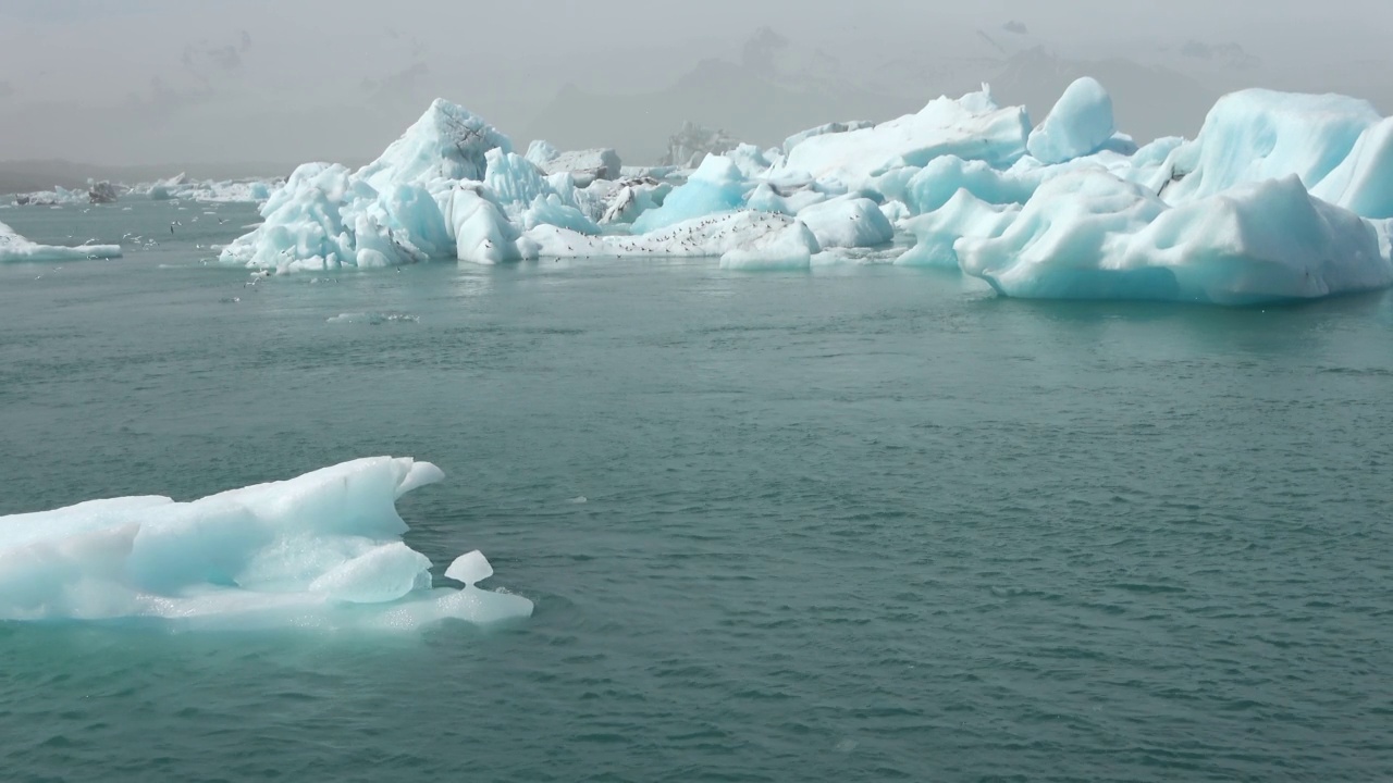 冰岛，Jokulsarlon泻湖，蓝绿色的冰山漂浮在冰岛的冰川泻湖。视频素材