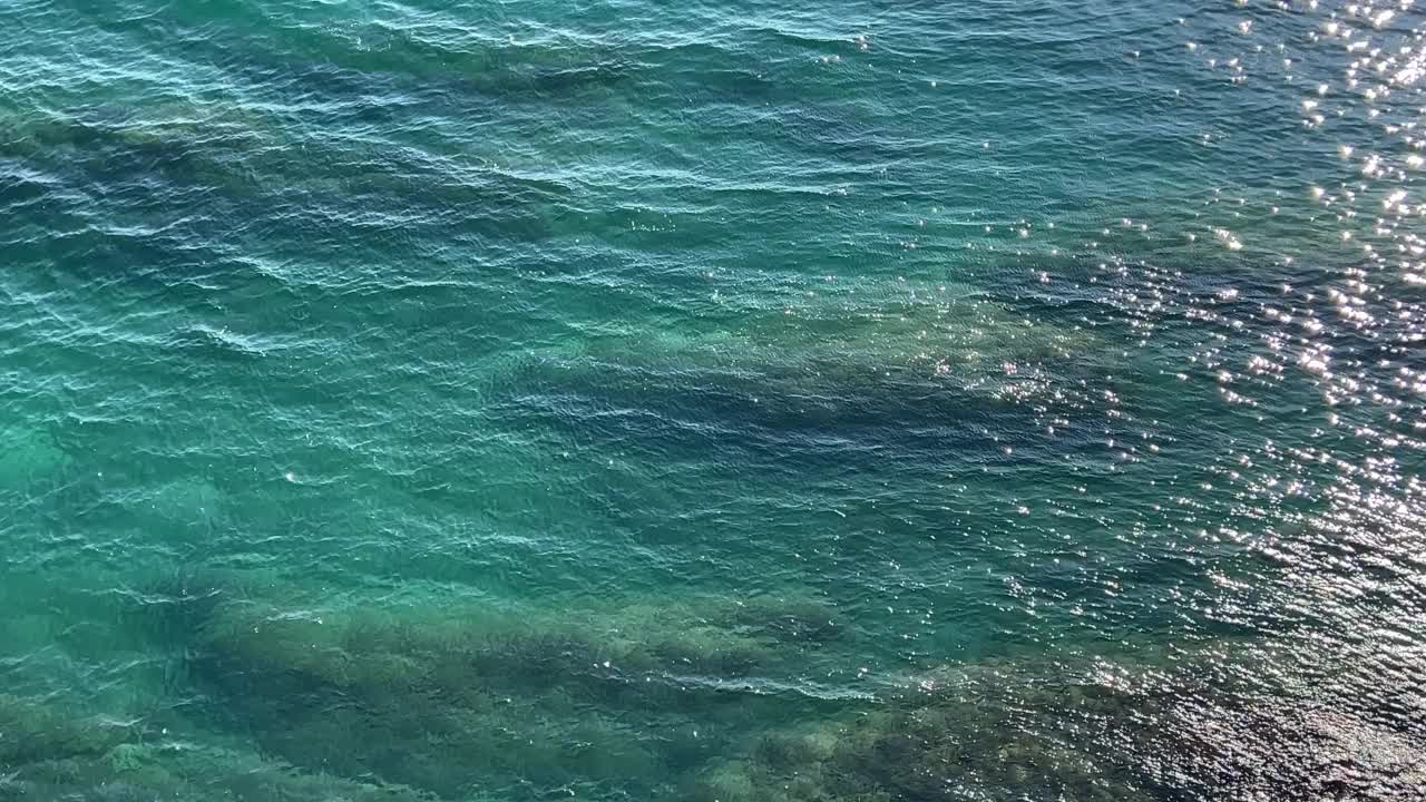 美丽的绿松石海景。波光粼粼的清澈海水。海水表面的波浪在阳光下闪闪发光。视频素材