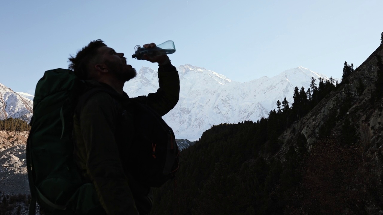 这名男子在喜马拉雅山南迦帕尔巴特的风景中喝水视频素材