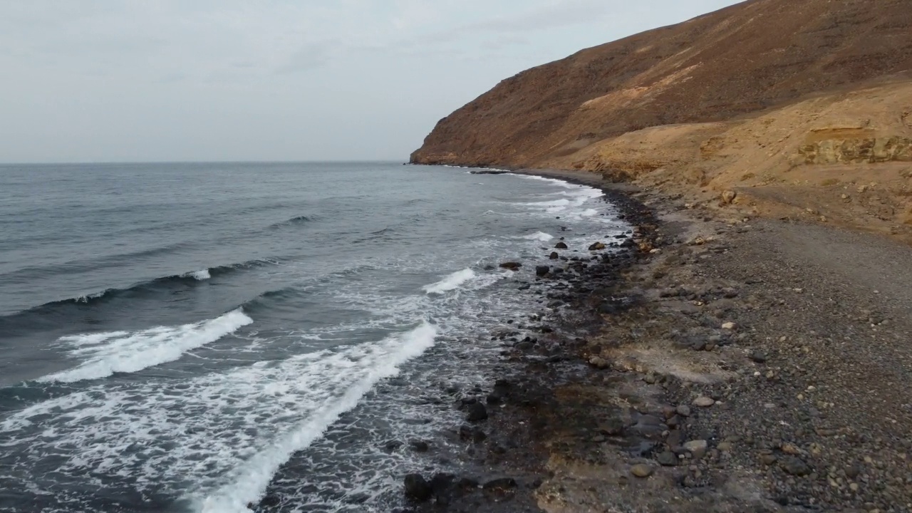 在西班牙富埃特文图拉海岸的岩石海滩和悬崖边飞行视频素材